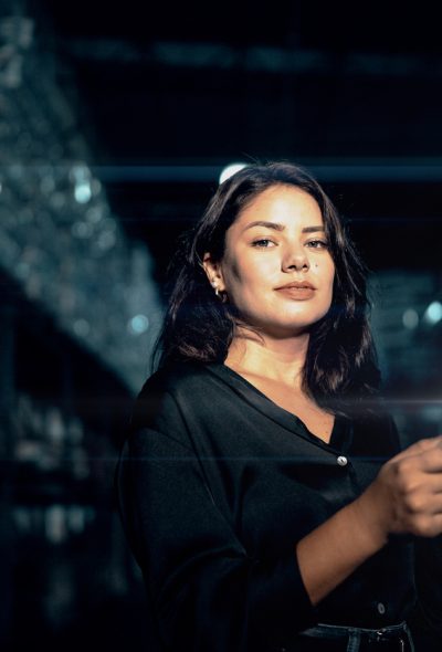 Portrait of a young woman analyzing graphs on digital intelligence in a warehouse