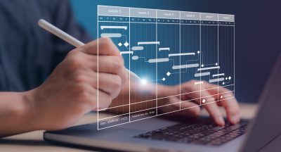 Project management concept. Site manager working with Gantt chart schedule for plan tasks and progress. Planning software. Corporate strategy for construction, finance, operations, sales, marketing.